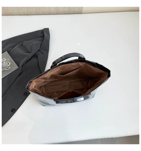 Detail view showing large capacity interior with zip pocket and brown lining of tote bag