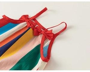 Detail of colorful striped summer dress with red shoulder straps and bow accents