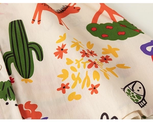 Gros plan du tissu en coton avec imprimés cactus et cerf et détails de couture de robe