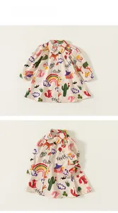 Détails d'une robe enfant en coton à imprimé dessin animé avec boutons et motifs colorés
