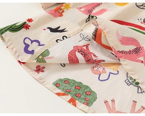 Zoom sur le tissu en coton avec motifs de renard et d'oiseau pour robe chemise d'enfant