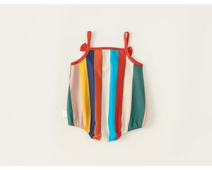 Detailed close-up of rainbow striped baby romper with red shoulder bows and soft cotton fabric
