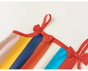 Detail of colorful striped cotton linen dress with red bow shoulder straps for girls