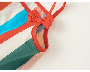 Macro shot of colorful striped fabric with orange bow detail on a girls summer dress