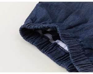 Detail of dark blue denim fabric showing high-quality elastic waistband texture and stitching