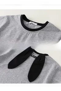 Dettaglio della maglietta grigia in maglia con orecchie da coniglio 3D e girocollo a contrasto