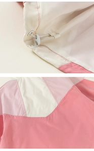 Detail der farblich abgesetzten Windjacke mit verstellbarem Kordelzug und Nähten