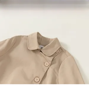 Detailed close-up of beige twill jacket collar and resin buttons on children's outerwear