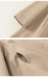 Detailed view of the khaki children's trench coat featuring fine twill texture and stitching