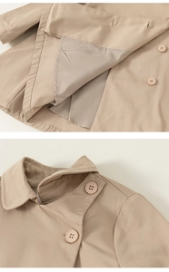 Detail of khaki trench coat featuring double-breasted resin buttons and twill texture