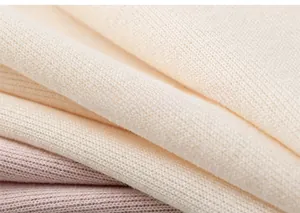 Gros plan sur le tissu en maille côtelée douce beige et rose clair pour enfant