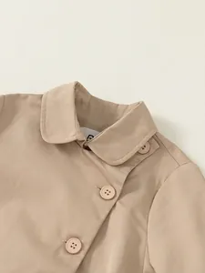 Close-up of a light khaki toddler trench coat with double-breasted buttons and lapel collar