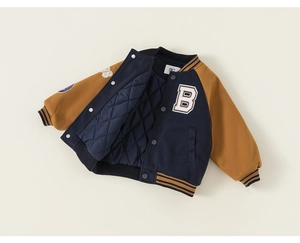 Detail of kids varsity jacket featuring yellow sleeves and quilted diamond lining