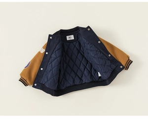 Detail of kids baseball jacket with quilted diamond lining and metal snap buttons