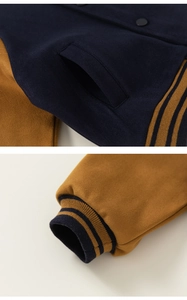 Detail of navy and yellow baseball jacket showing ribbed cuffs and slanted pockets