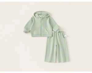 Détail d'une veste à capuche vert clair en maille gaufrée et d'un pantalon large pour enfant