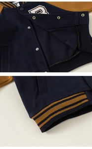 Detailed macro of kids varsity jacket with towel embroidery B and premium snap buttons