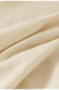 Detail shot of soft beige jacquard fabric with breathable weave texture and floral patterns