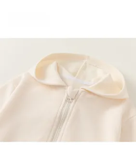 Détails macro du tissu côtelé et de la fermeture éclair de cette veste à capuche beige