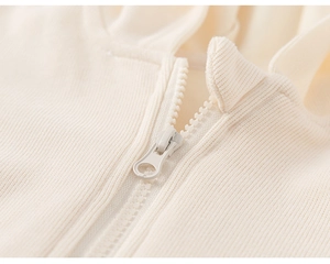 Gros plan d'un sweat à capuche enfant crème avec maille texturée et fermeture éclair assortie