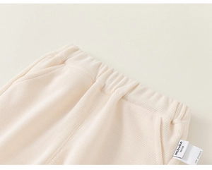 Vue détaillée du pantalon en maille côtelée blanc crème avec taille élastique et étiquette