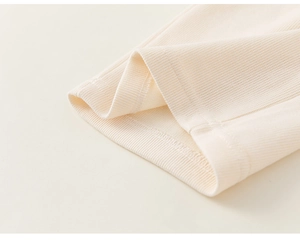 Détail des poignets côtelés et des coutures plates sur un vêtement en tricot pour enfant