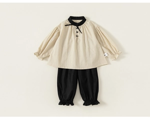 Close-up of girls' cotton linen set featuring beige puff sleeve top and black lantern pants