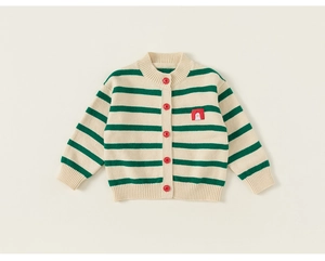 Detailed close-up of green and white striped knit cardigan with red buttons and penguin patch