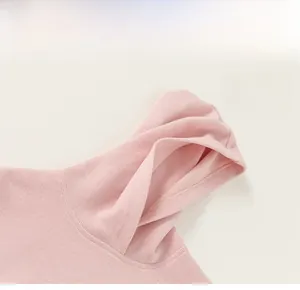 Close-up of pink hooded sweatshirt showing fine stitching and soft knit texture details