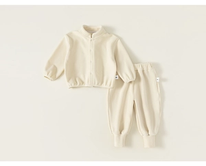 Détail à plat d'un ensemble sweat et pantalon en polaire crème avec boutons doux