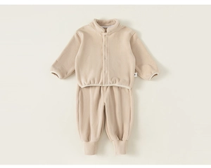 Détail à plat d'un ensemble de détente en polaire beige pour bébés et enfants