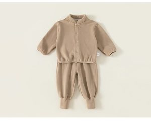 Détail à plat d'un ensemble deux pièces en polaire beige pour bébé avec col montant et bords-côtes