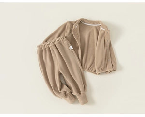 Détail montrant la texture épaisse du polaire doux et les coutures de l'ensemble bébé