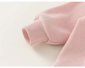 Close-up of pink hoodie sleeve showing elastic ribbed cuff and soft knit fabric texture