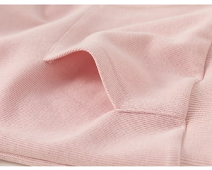 Close-up detail of smooth stitching on a soft pink cotton hoodie pocket and knit fabric