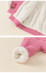 Detail van roze gebreid vest met dikke witte imitatie lamswollen voering en kabelpatroon