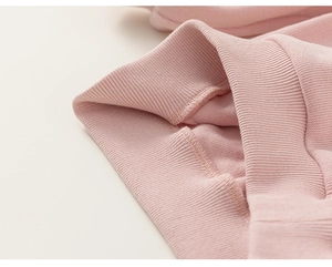 Close-up of elastic ribbed cuffs and sewing detail on pink cotton children's hoodie