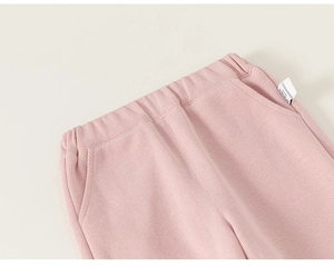 Detailed close-up of pink corduroy toddler pants featuring elastic waist and woven label
