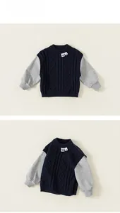 Detail of knit navy and grey patchwork sweater for boys with textured cable stitch design