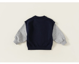 Detail of boys' navy knit sweater with light grey sleeve stitching and ribbed hem