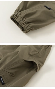 Detailed view of elastic cuffs and brand label on olive green cargo pants for kids