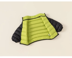 Detail of kids outdoor jacket with black windproof shell and bright neon green lining