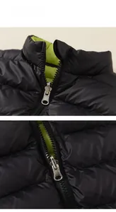 Detail of black windbreaker with neon green lining and silver metal zipper closure