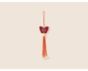 Close-up of butterfly embroidery with red silk thread and long beaded tassels