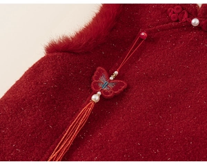 Detail of red Chinese New Year dress with fur collar, pearl buttons and butterfly tassels