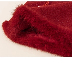Detail of red festive dress featuring white faux fur trim and silver glitter fabric finish