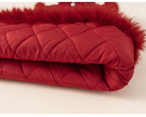Close-up of quilted dark red fabric with luxurious faux fur trim on girl's party dress