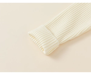 Detailed view of ribbed knit cuffs on cream long-sleeve winter dress for girls