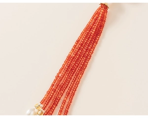 Detail of bohemian orange seed bead fringe with white pearls and gold accents