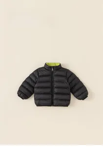 Flat lay of reversible kids puffer jacket in black and bright green contrast